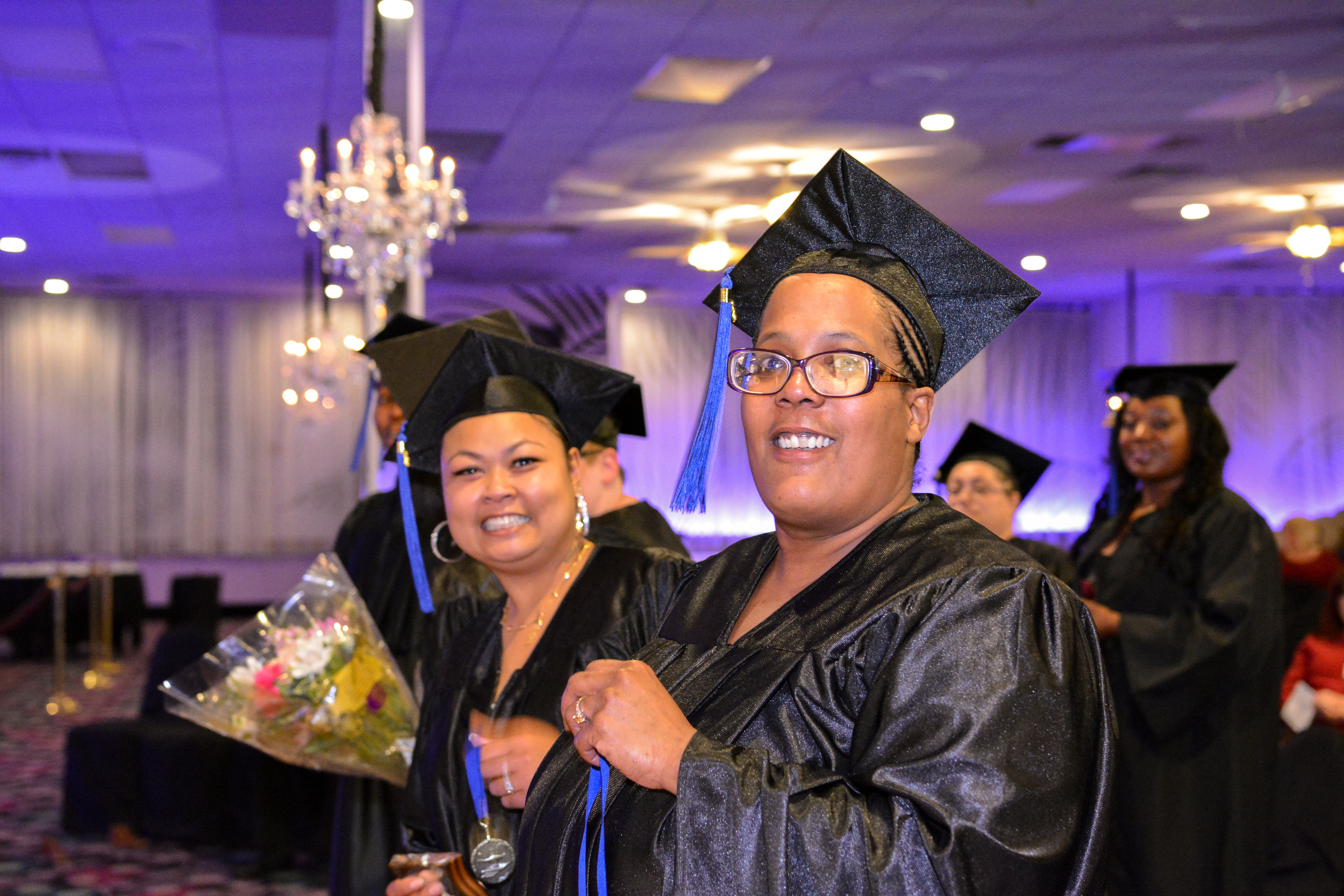 Trainees smiling at their graduation ceremony.